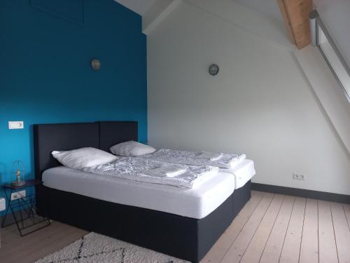 阿布考德Landelijk appartement in een mooi recreatiegebied的蓝色墙壁间的一张床位