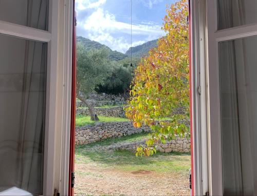 瓦西Pandora Villa的开放式窗户享有石墙的景致