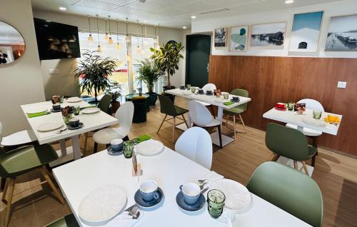 塞纳河畔伊夫里Residhome Quai d’Ivry的一间设有白色桌椅的餐厅