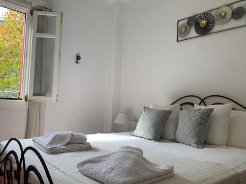 瓦西Pandora Villa的白色卧室配有一张挂在墙上的带时钟的床