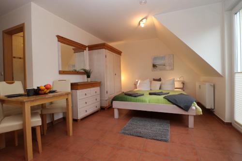 Neuhaus"Strandkoje" Strandkoje, App 07的一间卧室配有一张床、一张桌子和一张书桌