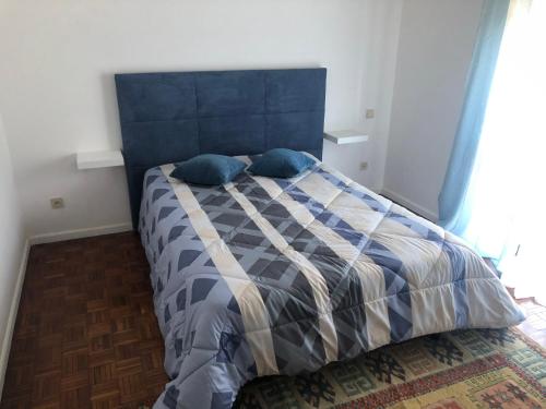 维拉·诺瓦·达·塞尔维尔Apartamento Rio Minho的卧室里一张带蓝色床头板的床