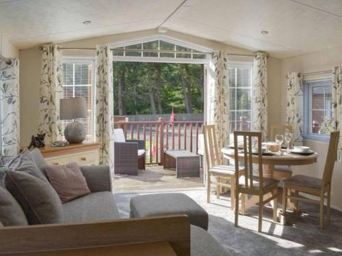 格伦德文Poppy Lodge Glendevon Scotland的客厅配有沙发和桌子