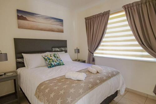 逊邱伦The Lemon Tree Oasis - Solar的一间卧室配有一张床,上面有两条毛巾