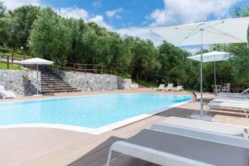 圣焦万尼亚皮罗特努塔特里博斯克酒店的一个带庭院和遮阳伞的游泳池