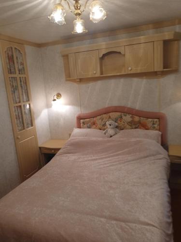 希尔内斯warden springs caravan park MS16 Thornhill road, Eastchurch,ME124HF的卧室床上的泰迪熊