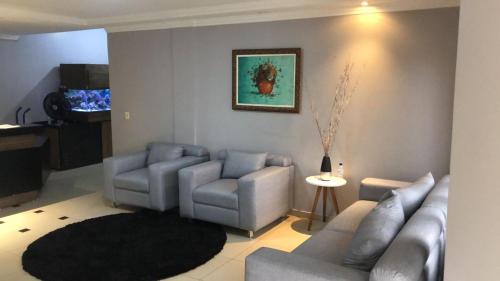 戈亚尼亚Acalantus Hotel的客厅配有两张沙发和地毯。