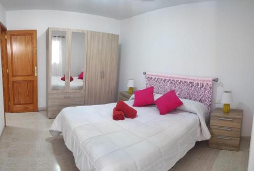 宏达海滩Casa La Orilla 1的卧室配有带红色枕头的大型白色床