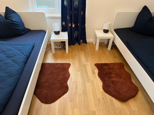 莱比锡Gemütliches Appartement am Völkerschlachtdenkmal的一间设有两张床和两张带地毯的桌子的房间