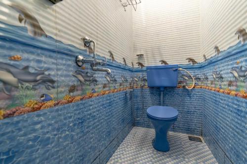 安君纳Whoopers Hostel Anjuna, Goa的浴室设有蓝色的卫生间和鸭子壁画