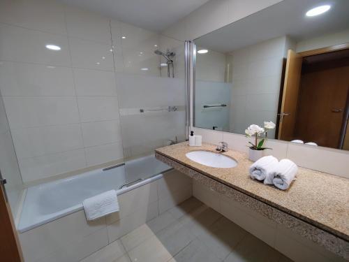 巴达洛纳Badalona Beach Apartment的一间带水槽、淋浴和镜子的浴室