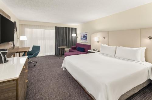 奥兰多Crowne Plaza Orlando - Lake Buena Vista, an IHG Hotel的酒店客房设有一张白色大床和一张书桌