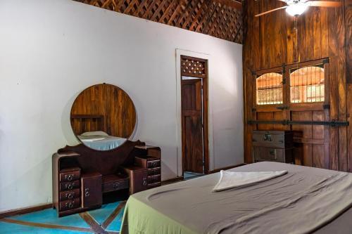 里瓦斯Casa Hacienda El Menco的一间卧室配有一张床和镜子