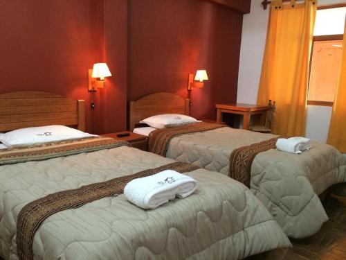 瓦拉斯经典哈卡尔旅馆的酒店客房,配有三张床和毛巾