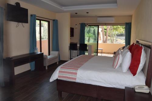 查帕拉查帕拉乡村酒店的一间卧室配有一张床、一张书桌和一台电视