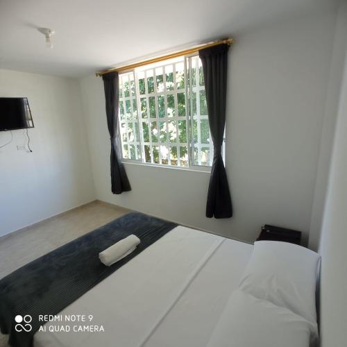索科罗confortable apto integrado con la naturaleza y muy tranquilo perfecto para descansar的卧室配有白色的床和窗户。