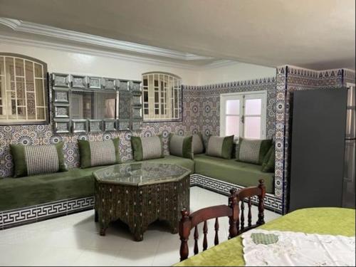 沃利迪耶Appartement chems的客厅配有绿色沙发和桌子