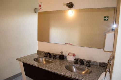 罗萨里奥Hostel Point的一间带两个盥洗盆和大镜子的浴室