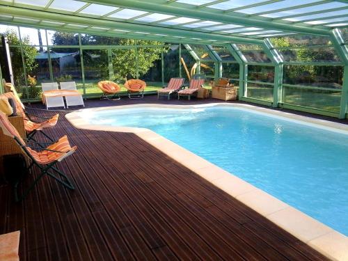 CoulainesChambre d'hôte avec piscine couverte的房屋旁的木甲板上的游泳池