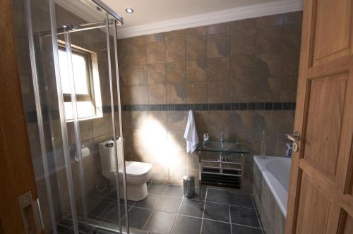 逊邱伦优伊特希格帕克旅客@home4U酒店的带淋浴、卫生间和浴缸的浴室