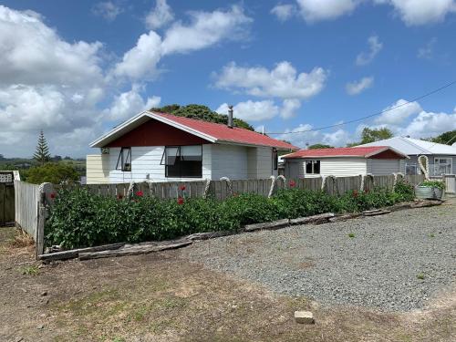 Te KopuruPeaceful Riverfront cottage in small northland town的院子前有围栏的房子