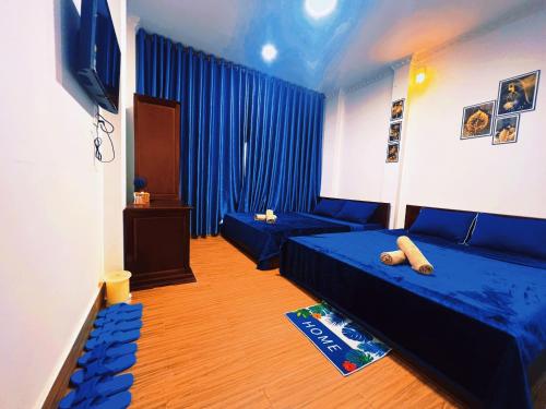 芹苴Nhan Tay Hostel的客房设有两张床、一张沙发和一台电视。