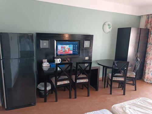 沙姆沙伊赫Bellissimo appartamento vista mare sulla piscina的客厅配有桌椅和电视