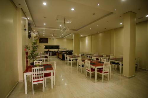 帕劳阿佩巴斯Atrium Express Hotels的用餐室配有桌子和白色椅子