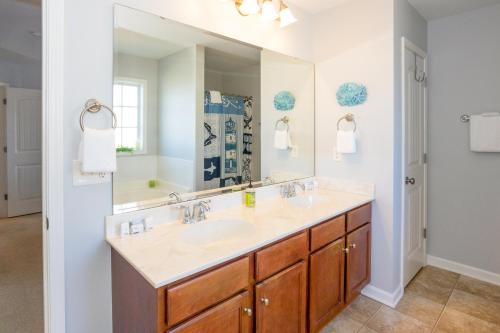 卡罗来纳比奇Carolina Comforts的一间带水槽和大镜子的浴室