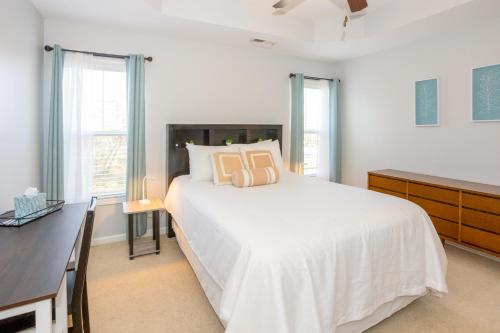 卡罗来纳比奇Carolina Comforts的卧室配有一张白色大床和一张书桌