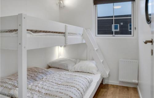 博托比2 Bedroom Nice Apartment In Vggerlse的白色的客房设有一张双层床,配有窗户