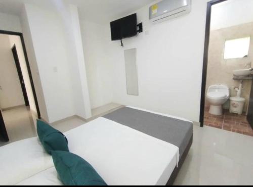 库库塔Aveiro Hotel的一间小卧室,配有一张床和一个卫生间