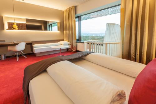 巴塞尔巴塞尔机场酒店 - 交通便利、热情友好的一间卧室配有一张大床、一张桌子和一个窗户。