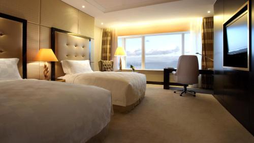 大连大连中远海运洲际酒店的酒店客房设有两张床和窗户。