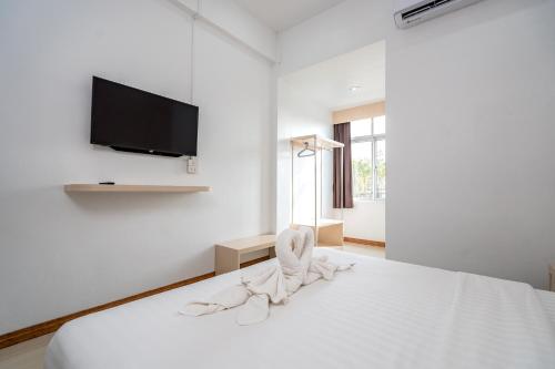 玛哈沙拉堪TOP INN โรงแรมท็อปอินน์的白色卧室配有一张床铺,墙上配有电视