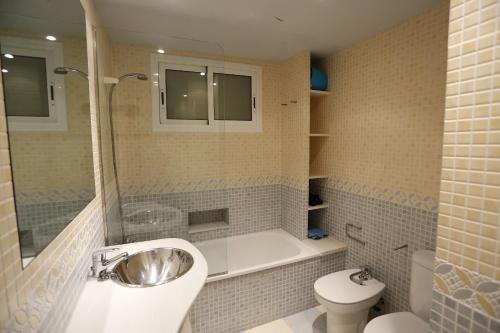 坎布里尔斯Apartamentos Alquihouse Vilafortuny的带浴缸、盥洗盆和卫生间的浴室