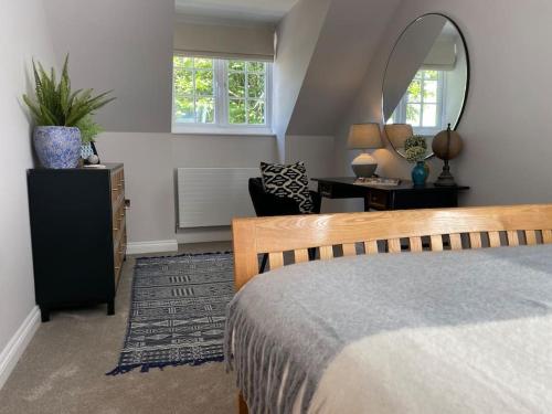 卡林顿Cornish country getaway的一间卧室配有一张床、镜子和一张书桌