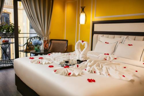 萨帕Eden Central Hotel & Spa的一张床上有天鹅,上面有玫瑰花