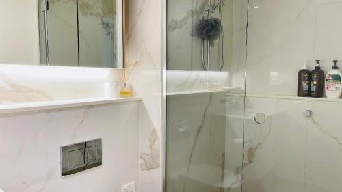 墨尔本Sweet Home Apartment North Melbourne的带淋浴的浴室和玻璃门