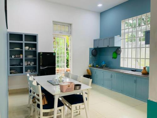 保禄Mon House的厨房配有蓝色橱柜和桌椅
