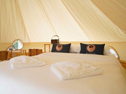 北冲Yellowstone Camps Resort Khao Yai的帐篷内的一张床位,上面有两条毛巾