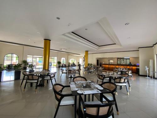 拉瓦格Plaza Del Norte Hotel and Convention Center的一间在房间内配有桌椅的餐厅