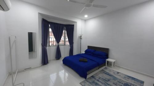 昔加末昔加末斯里佩兰民宿的一间卧室设有蓝色的床和窗户。