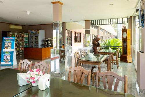 Sangkhaโรงแรมมณีสังขะ的一间带桌椅和时钟的用餐室