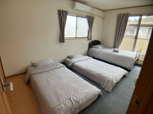Kuguta3 Bedrooms, 2 Toilets, 3 Car parking in Big Entire house Close to Makuhari Messe, Disneyland, airport and Tokyo for 12 guests的带三张床和窗户的客房