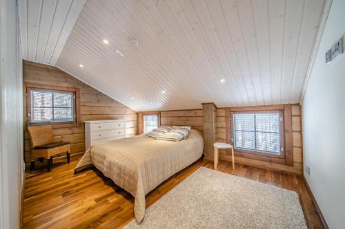 列维Villa Amiraali Levi的卧室配有一张床铺,位于带木墙的房间内