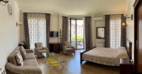 巴统艾菲尔酒店的一间卧室设有一张床和一间客厅。