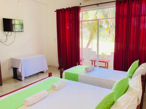 蒂瑟默哈拉默Sakalya Lake View的客房设有两张床和一个带红色窗帘的窗户。