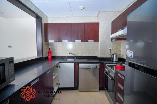 迪拜Alashrafia Saray 2BR apartment in Sport City的厨房配有木制橱柜和不锈钢用具