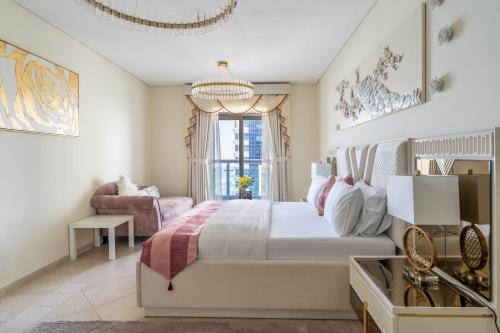 迪拜Veer Apartments - 82nd Floor Princess Tower - Palm View的一间卧室配有一张大床和一个吊灯。